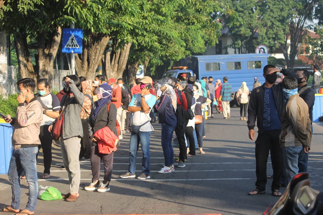 Peserta rapid test di Margorejo yang sampai meluber di jalan raya. (Foto: Asmanu Sudharso/Ngopibareng.id)