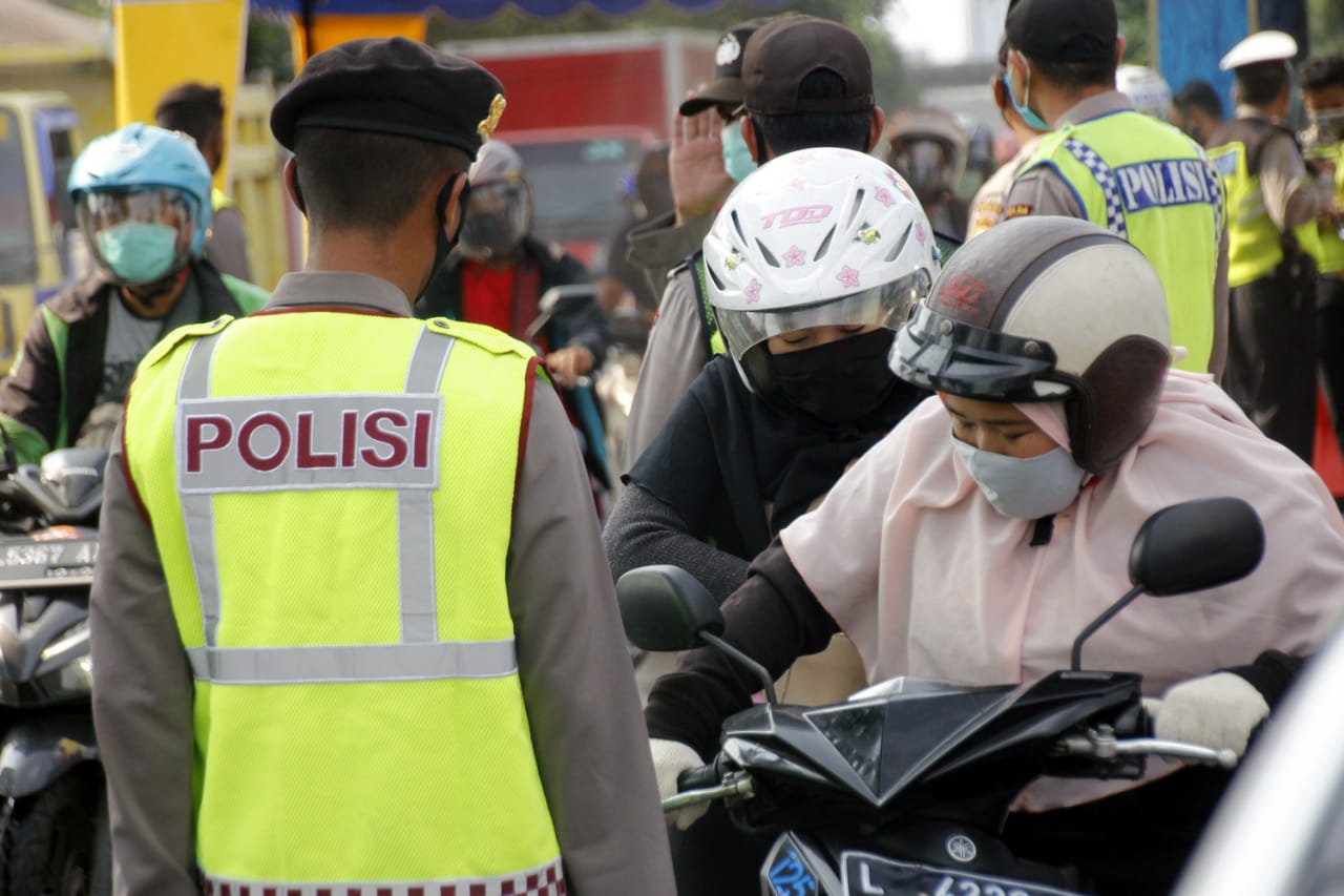 Petugas saat menghentikan pengendara yang nekat berboncengan ketika masa PSBB di Waru, Sidoarjo. (Foto: Fariz Yarbo/Ngopibareng.id)