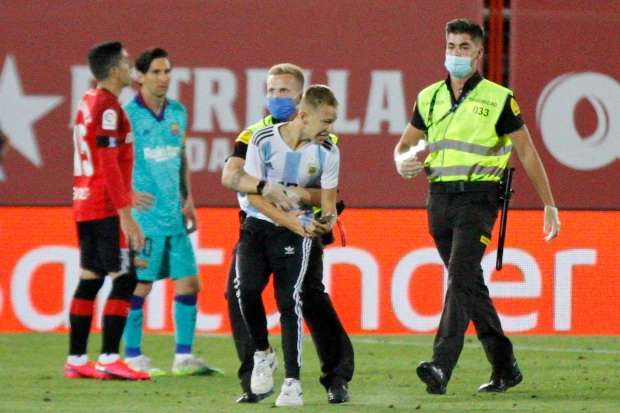 Si penyusup laga Real Mallorca vs Barcelona ditangkap petugas keamanan. (Foto: AP) 