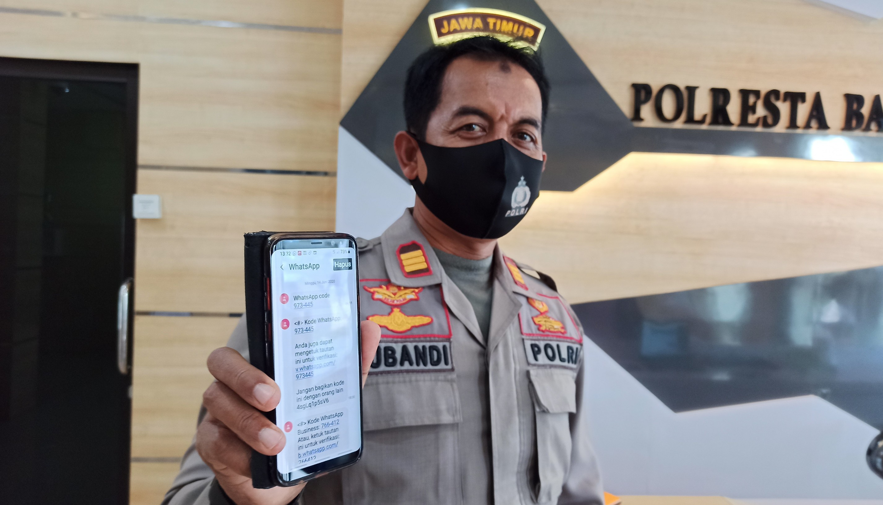 AKP Subandi menunjukkan SMS verifikasi yang ada di HP-nya. (Foto: Muh. Hujaini/Ngopibareng.id)