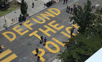 Orang-orang berjalan di 16th Street, dekat Gedung Putih  di Washington, D.C, yang betulisan tuntutan agar anggaran polisi dicabut. (Foto: Images)