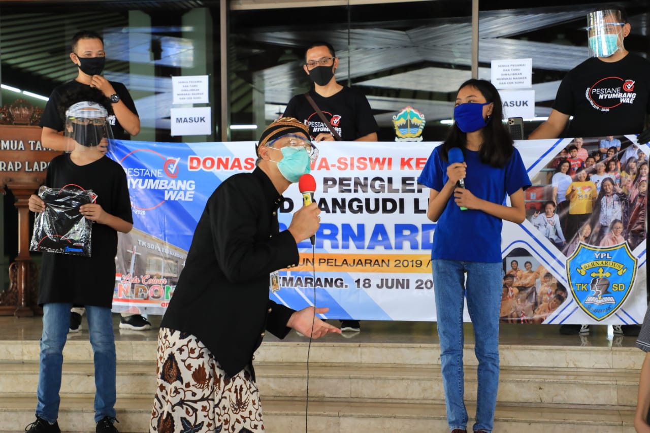 Gubernur Jawa Tengah Ganjar Pranowo saat menerima donasi dari lulusan SD Pangudi Luhur. (Foto: Ist/Ngopibareng.id)