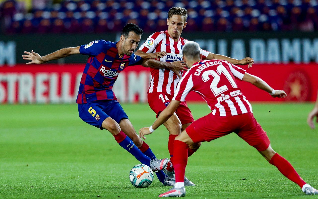 Sergio Busquets dihadag dua pemain Atletico Madrid. Laga berakhir imbang 2-2. (Foto: @FCBarcelona)