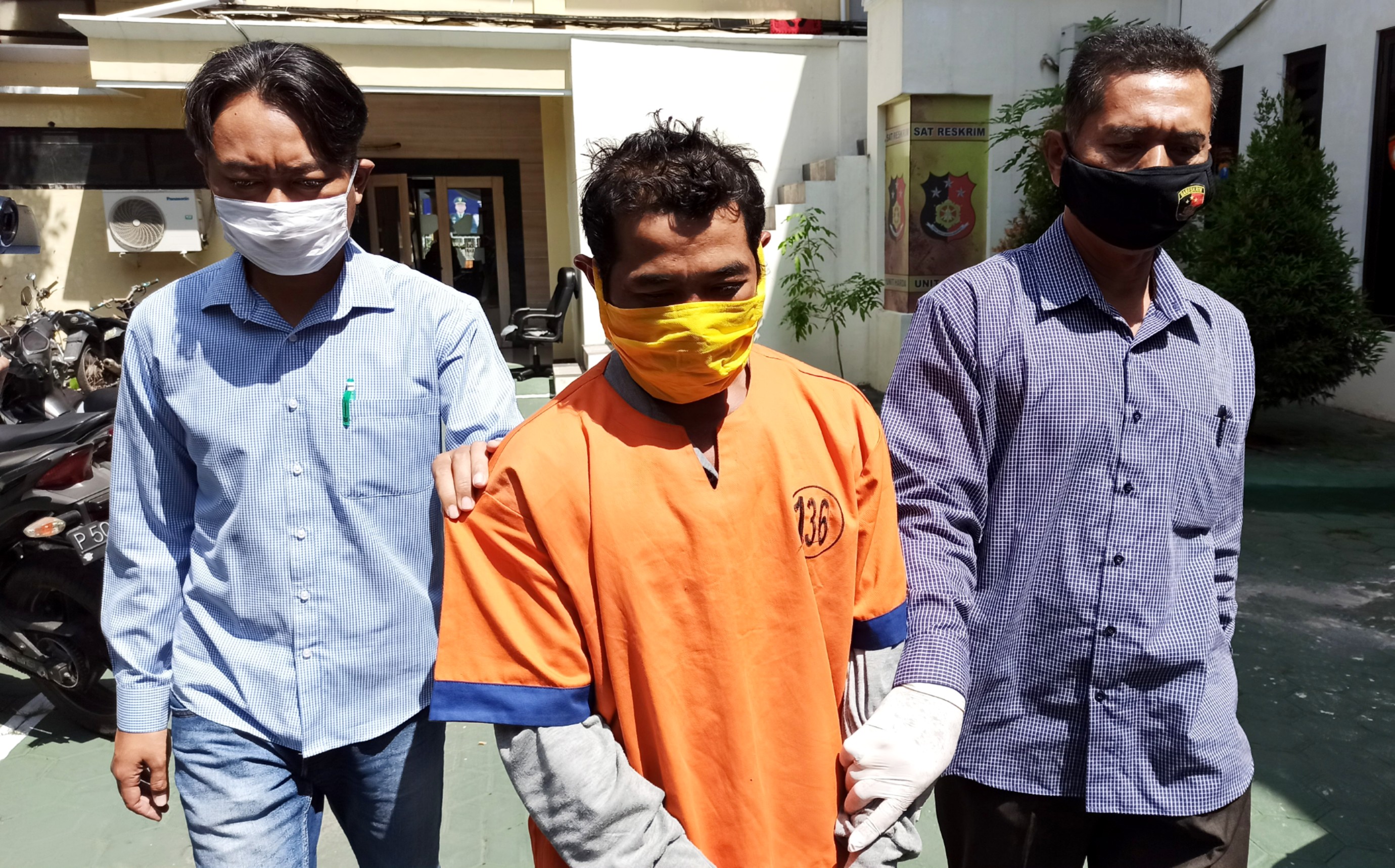 Polisi menggiring NW, pria yang diduga menikahi siri seorang gadis berusia 12 tahun (foto:Muh Hujaini/ngopibareng.id)