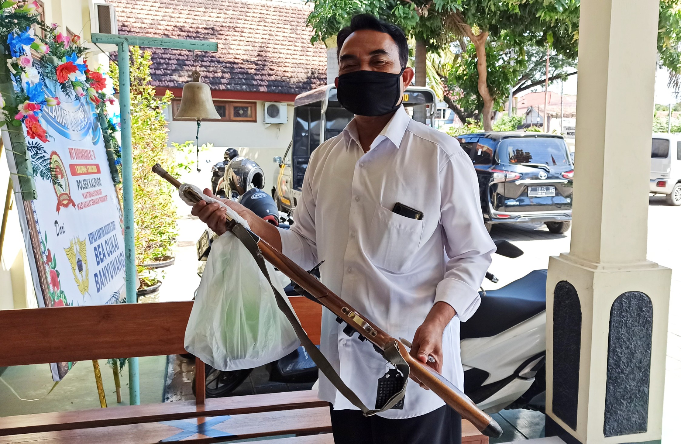 Kanit Reskrim Polsek Kalipuro Ipda Suyono menunjukkan senapan angin yang disita dari rumah korban (foto:Muh Hujaini/ngopibareng.id)