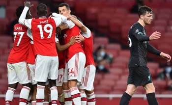 Pemain Arsenal merayakan kemenangan atas Liverpool 2-1, sementara pemain Liverpool, Andy Robertson nampak lunglai. (Foto:Reuters)