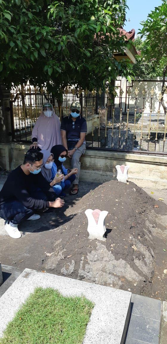 Keluarga Erwin saat mengunjungi pusara istrinya. (Foto: Dokumen keluarga)