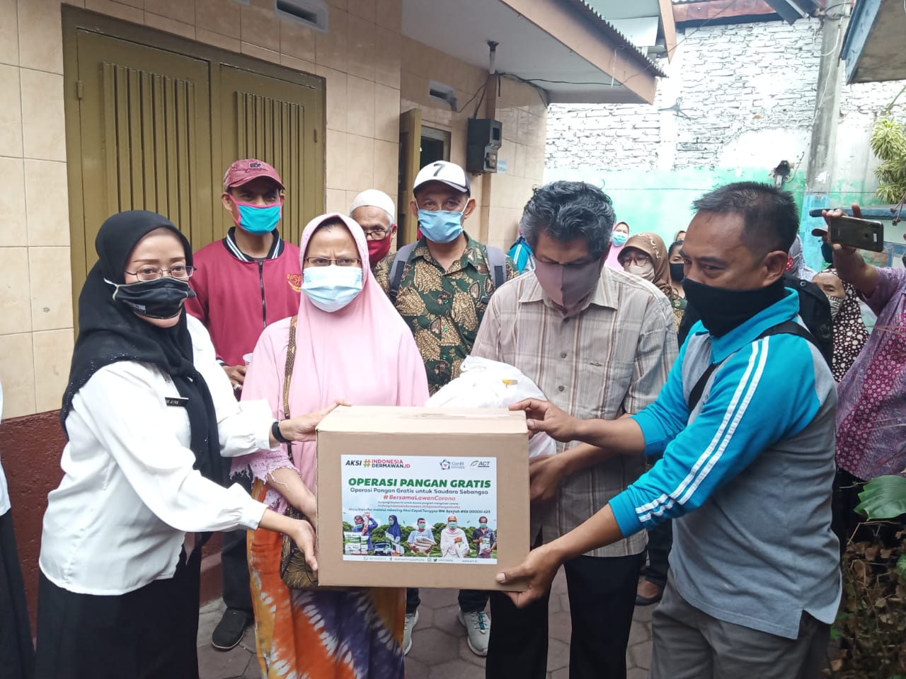 Kedua pasien Covid-19 saat diberikan bantuan sembako oleh warga sekitar (Foto: Lalu Theo/Ngopibareng.id)