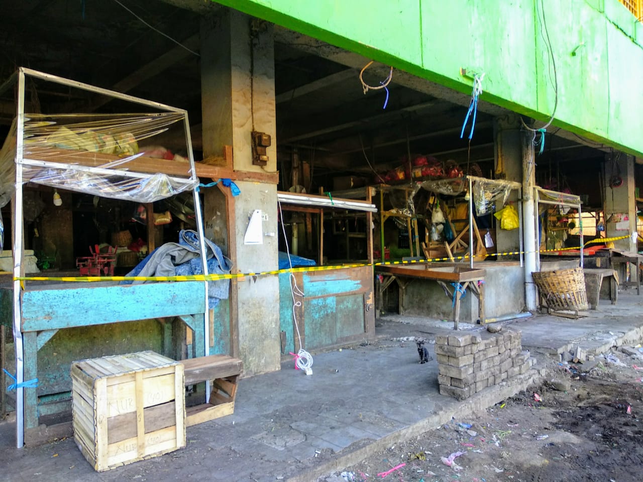 Pasar Keputran yang ditutup menggunakan garis polisi hitam dan kuning tampak sepi. Terlihat beberapa lapak berjualan pedagang yang dibiarkan kosong. (Foto: M.Rizqi/Ngopibareng.id)