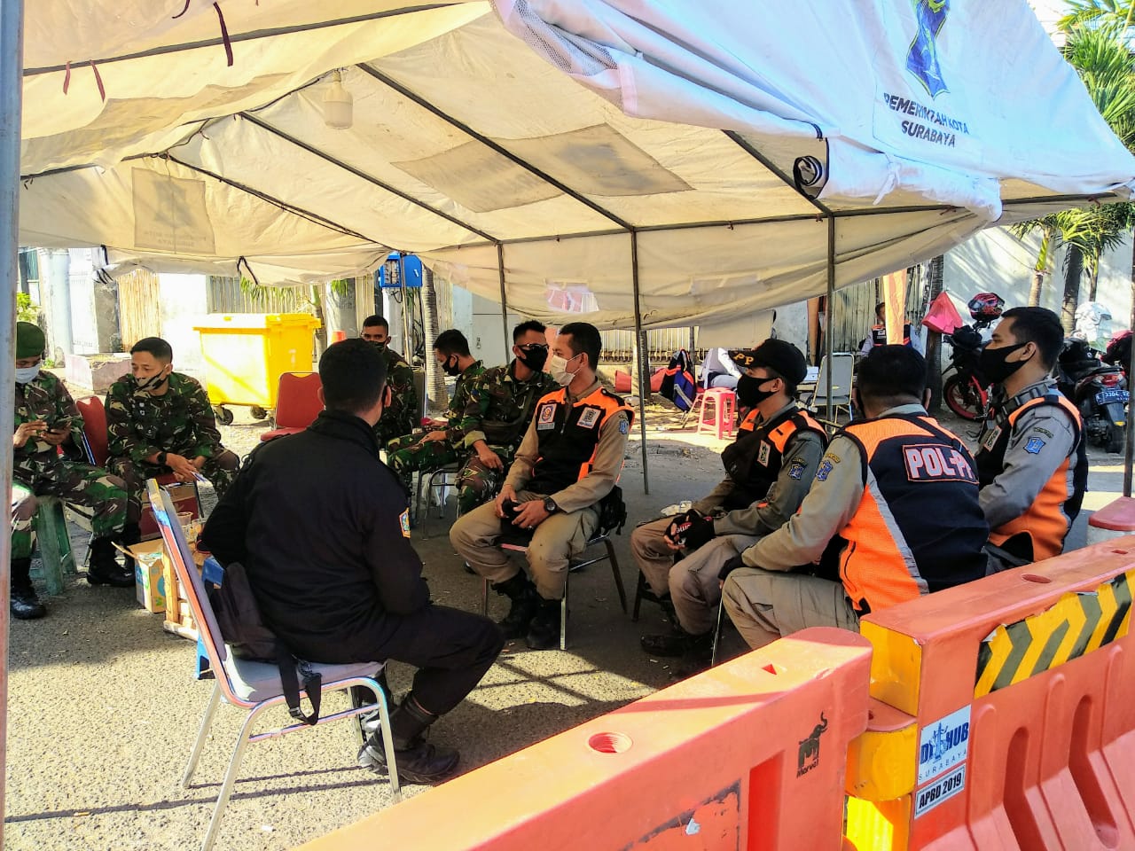 Petugas gabungan TNI dan Satpol PP bersiaga dan berjaga di portal pintu masuk menuju Pasar Keputran yang berlokasi di depan Jalan Sunda. (Foto: M.Rizqi/Ngopibareng.id)