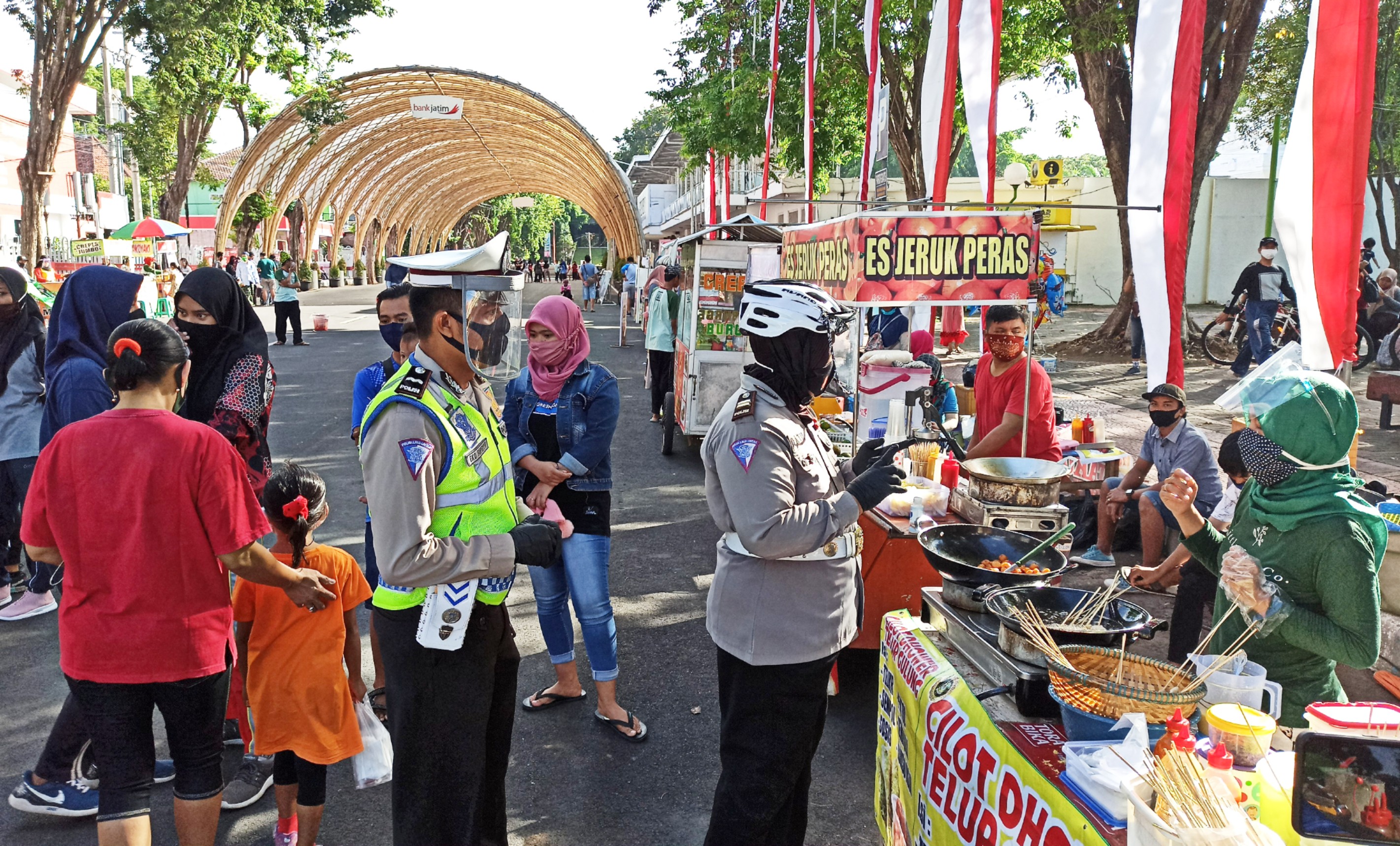 Kanit Dikyasa Satlantas Polresta Banyuwangi, Iptu Datik Hariyati, berbincang dengan salah satu pedagang di area CFD sambil mengingatkan untuk tetap menerapkan protokol kesehatan. (Foto: Muh Hujaini/Ngopibareng.id) 