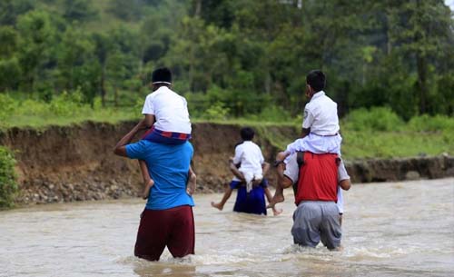 Guru dan siswa harus melintasi sungai Polanggua untuk melakukan aktivitas belajar mengajar karena belum tersedianya jembatan menuju SDN 6 yang berada di Desa Langge, Kecamatan Tapa, Kabupaten  Bone Bolango, Provinsi Gorontalo. (Foto:Antara/Adiwinata Solihin)