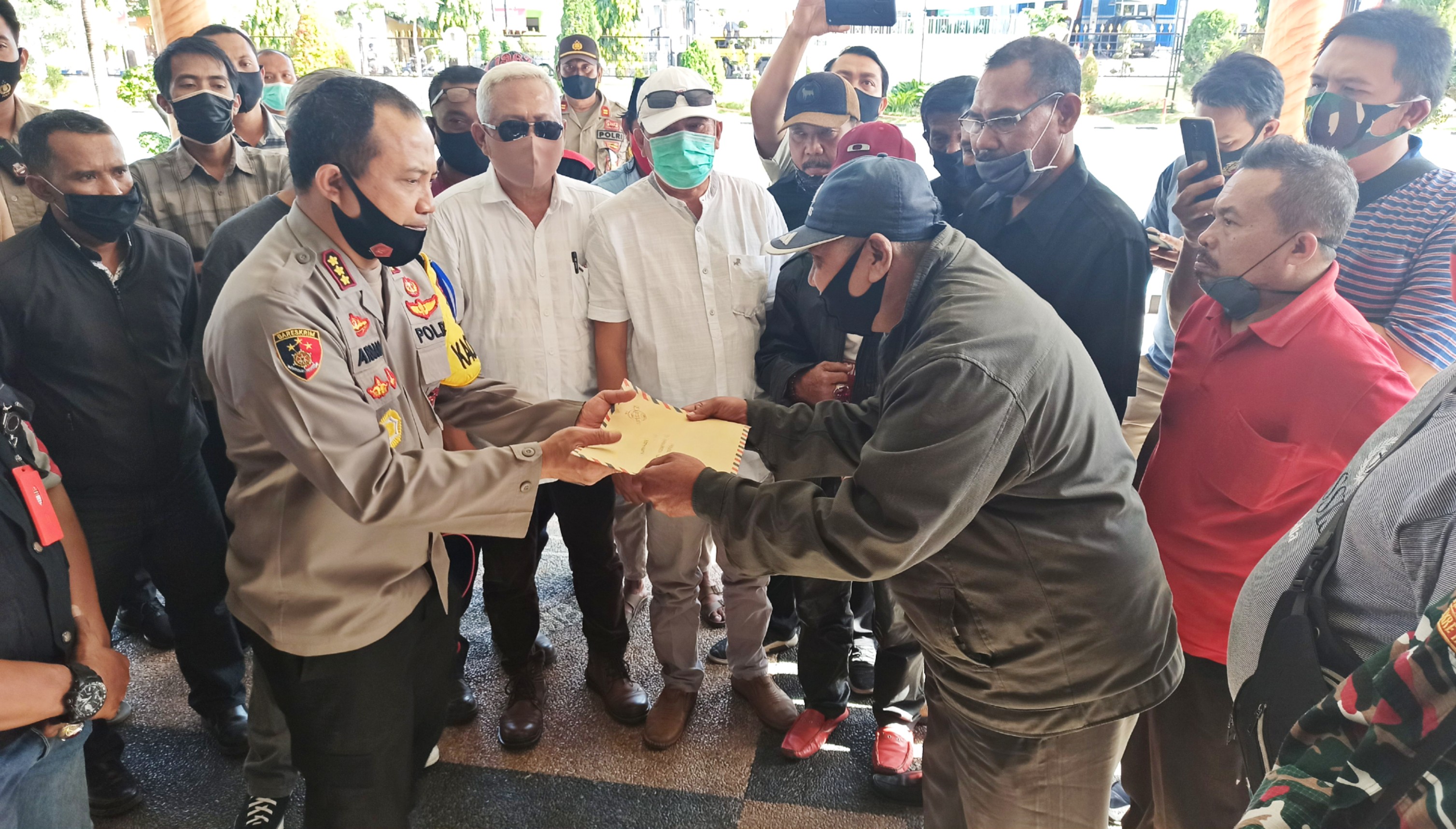 Perwakilan LSM menyerahkan Surat dukungan dan pernyataan sikap Lintas LSM Banyuwangi kepada Kapolresta Banyuwangi Kombespol Arman Asmara Syarifuddin di lobi Polresta Banyuwangi. (Foto: Muh. Hujaini/Ngopibareng.id)