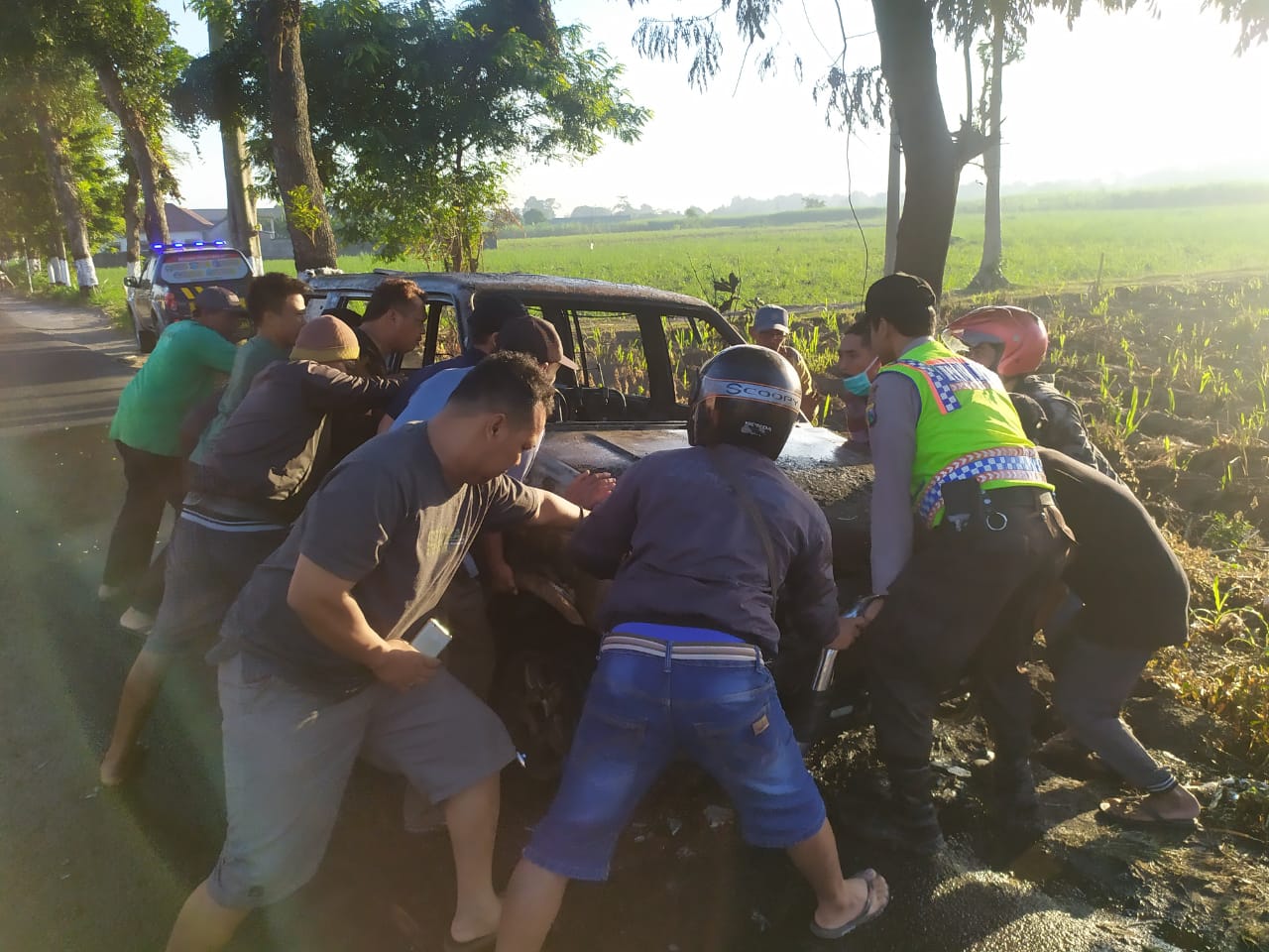 Warga brsama polisi memindahkan mobil ke pinggir jalan. (Foto: istimewa)