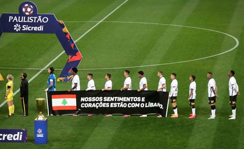 Para pemain klub  Corinthians di Liga Brazil, memegang spanduk untuk menghormati para korban ledakan Beirut sebelum pertandingan leg pertama Campeonato Paulista, melawan klub Palmeiras di stadion Itaquera di Sao Paulo, Brasil. (Foto:Fernando Bizerra/ EPA)
