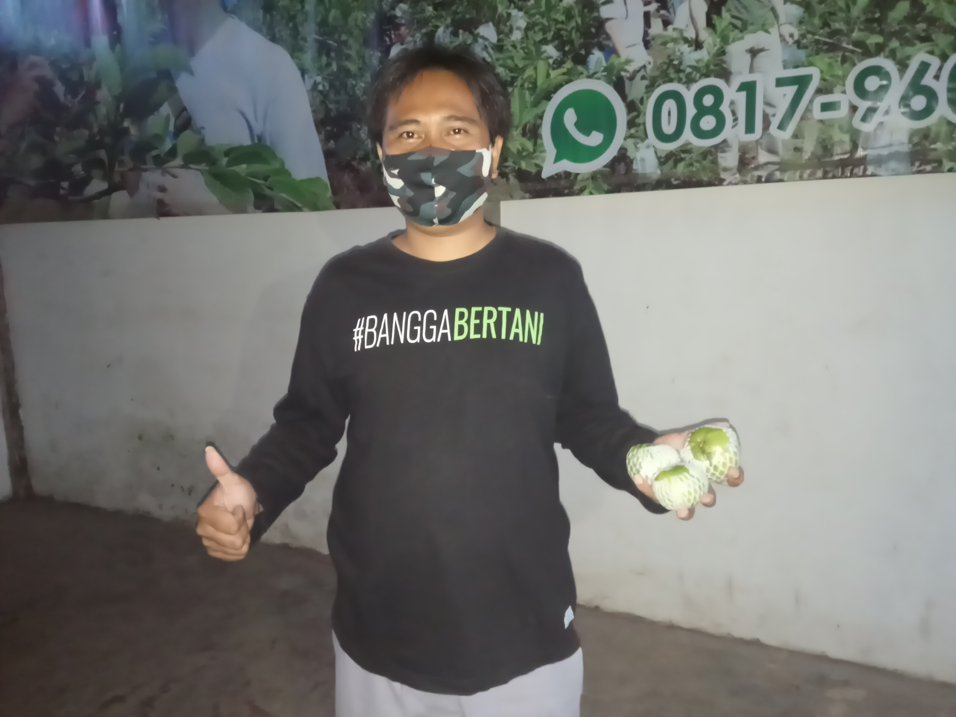 Petani Millenial, Rakhmad Hardiyanto memegang jambu kristal di kebunnya di Desa Bumiaji, Kecamatan Bumiaji, Kota Batu (Foto: Lalu Theo/Ngopibareng.id) 