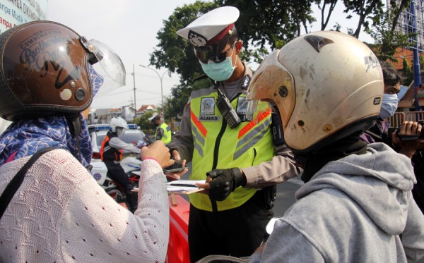 Aparat menegur pengendara yang melanggar aturan protokol kesehatan. (Foto: Fariz Yarbo/Ngopibareng.id)