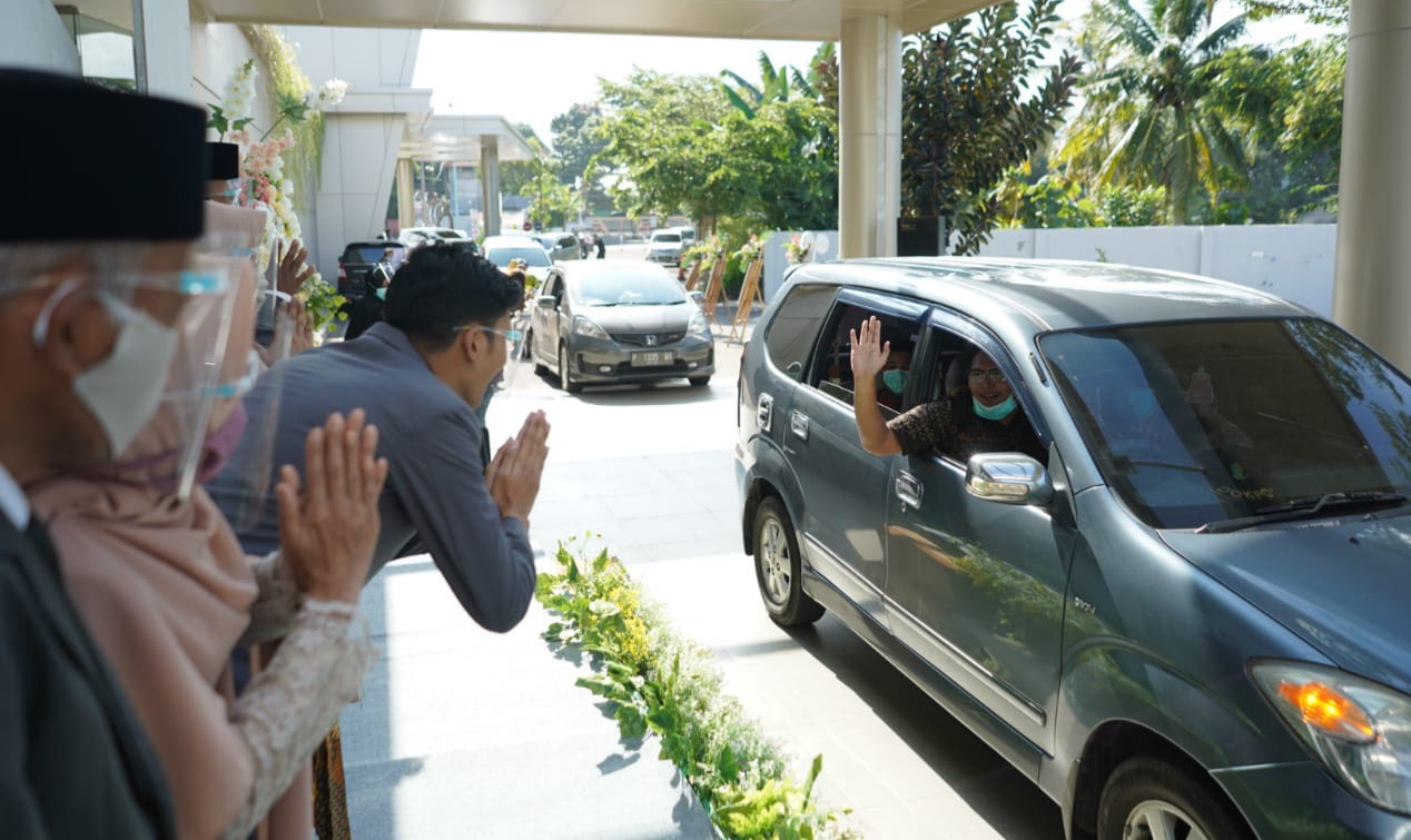 Tamu undangan melambaikan tangan kepada mempelai dari dalam mobil (foto:istimewa)