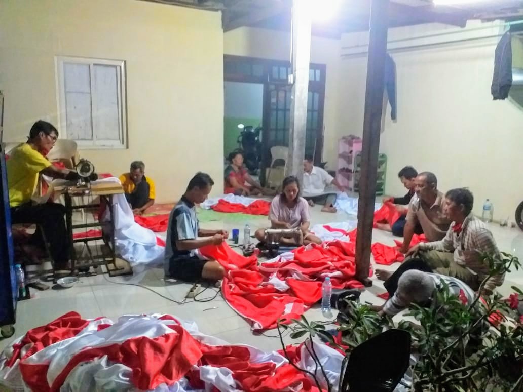 Warga Dukuh Karangan Surabaya saat menjahit bendera di ruamh salah satu warga (Foto: M.Rizqi/Ngopibareng.id)