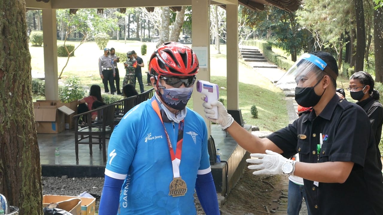 Peserta Tour de Borobudur melakukan protokol kesehatan Covid-19 dengan cek suhu tubuh dengan thermo gun. (Foto: Istimewa)
