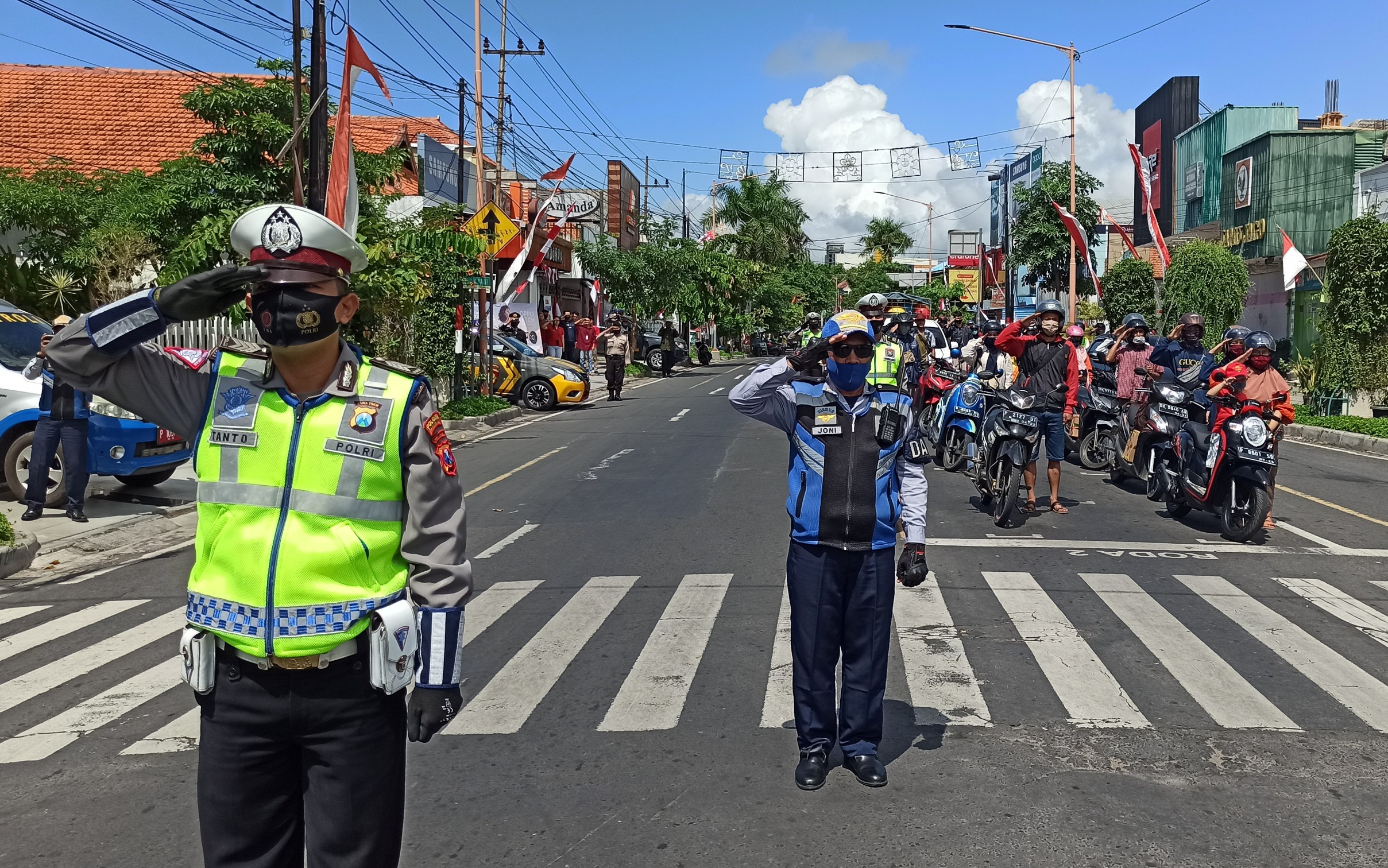 Polantas, pengendara dan warga yang berada di sekitar Simpang Lima Banyuwangi memberikan penghormatan pada saat detik-detik proklamasi (foto: Muh Hujaini/Ngopibareng.id)