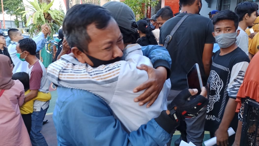 Seorang narapidana Lapas Kelas IIA Banyuwangi menangis haru sambil berpelukan dengan keluarganya saat bisa keluar Lapas,  18 Agustus 2020. (Foto: Muh. Hujaini/Ngopibareng.id)