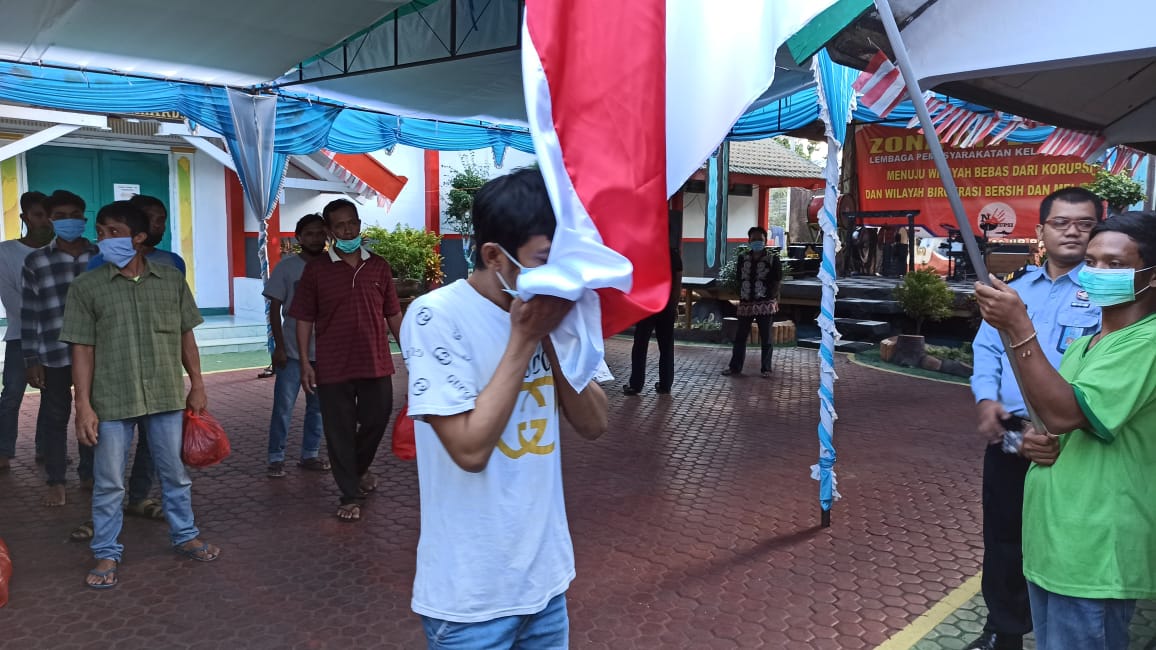 Salah satu narapidana mencium bendera merah putih sebelum meninggalkan Lapas Kelas IIA Banyuwangi, 18 Agustus 2020. (Foto: Muh. Hujaini/Ngopibareng.id)