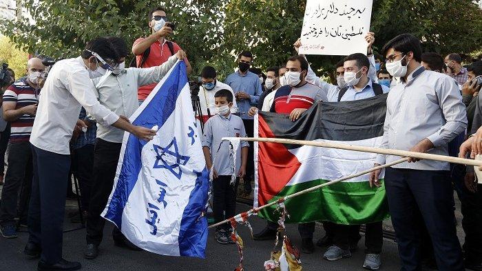 Para mahasiswa membakar bendera Israel dan AS dalam demo menentang pembukaan hubungan UEA dengan Israel di depan Kedubes UEA di Teheran, Iran, Sabtu 15 Agustus 2020. (Foto: afp)