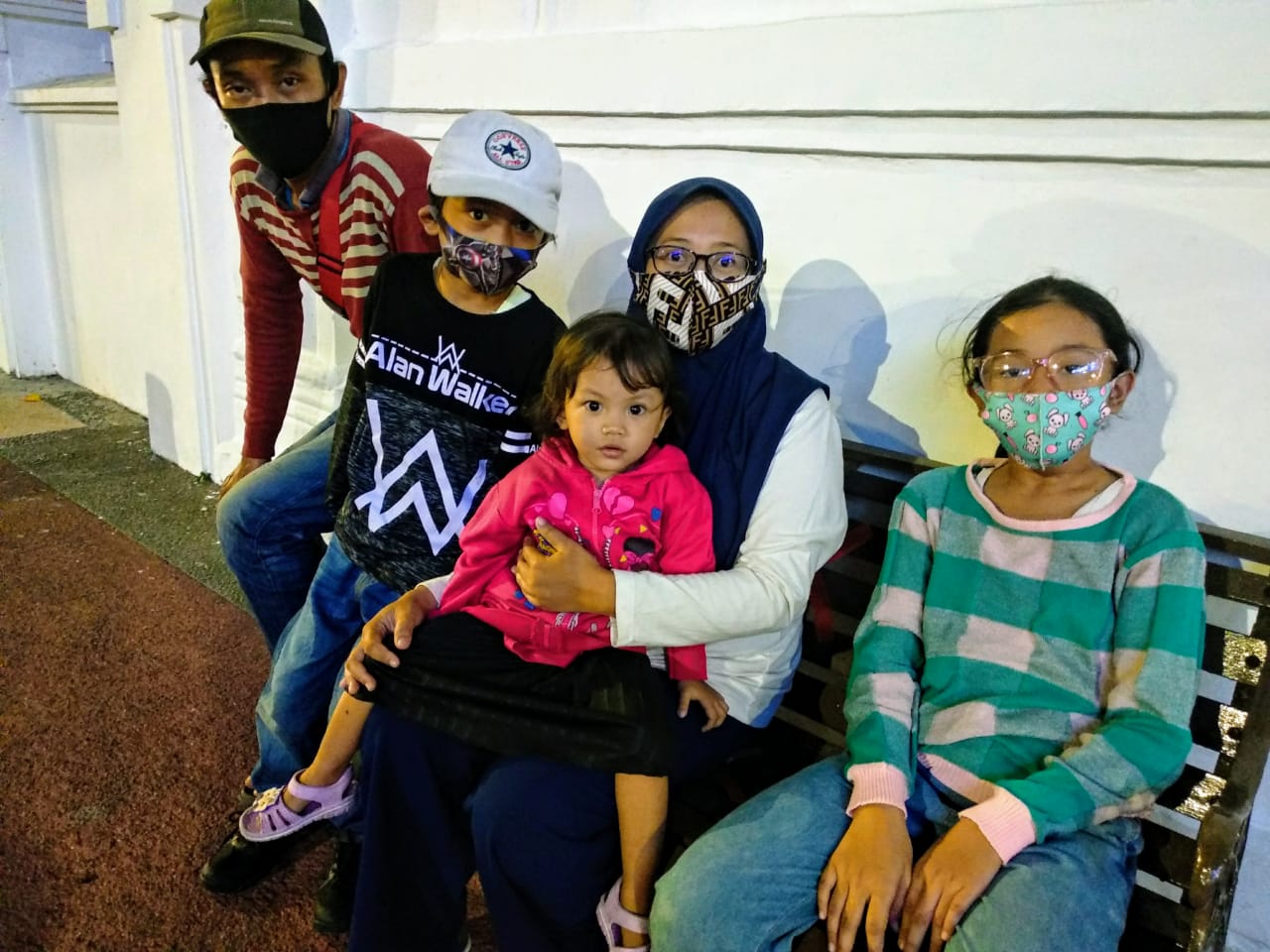 Ganda Suryana (kiri), Galuh Fajri (bertopi putih), Agnes Darizky (memangku putrinya Asa Binar Kirania) dan Gea Amabel (kanan berbaju hijau). Ganda dengan rombongan keluarganya ini menunggu bus Kota Surabaya menuju Kedarus. (Foto: M.Rizqi/Ngopibareng.id)