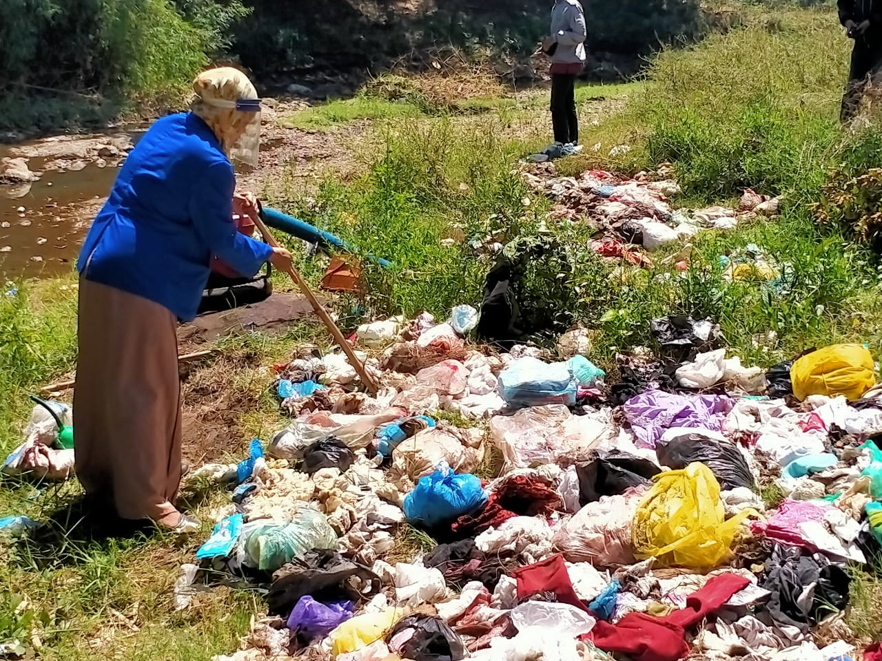 Dewi Puspa Ernawati, mahasiswi Universitas Zainul Hasan (Unzah), Genggong, Kabupaten Probolinggo, memeriksa tumpukan sampah di Sungai Kedungjambon. (Foto: Ikhsan Mahmudi/Ngopibareng.id)