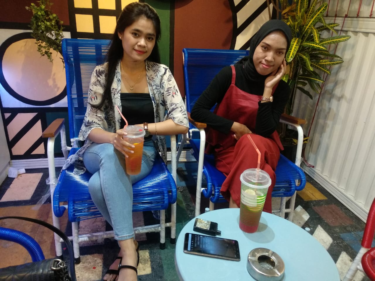 Nur Fadila Ulfa (kiri) saat bersantai di Mini Tropikal ditemani temannya pada Sabtu, 29 Agustus 2020 pukul 18.00 WIB. Fadila terkagum dengan packaging plastik minuman yang menurutnya unik. (Foto: M.Rizqi/Ngopibareng.id)