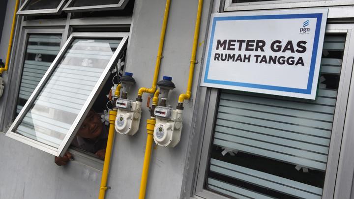 Seorang warga mengamati meteran gas yang terpasang di dinding rumahnya di salah satu rumah susun di Surabaya, Jawa Timur, 7 Mei 2019. Selain Surabaya, PGN juga membangun jaringan gas bumi di sejumlah daerah di Indonesia. Pembangunan infrastruktur gas itu menjadi prioritas utama PGN mengingat semakin besarnya kebutuhan energi yang lebih efisien. (Foto: Antara/Zabur Karuru)