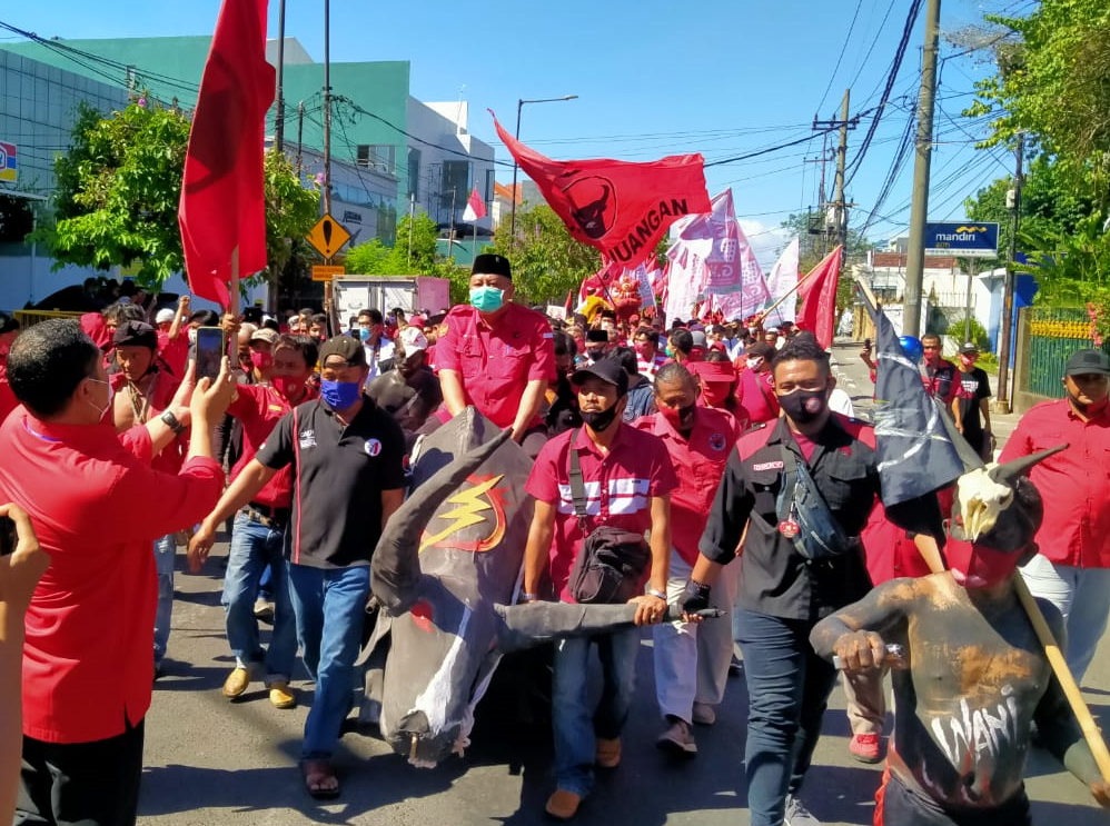 Whisnu Sakti yang batal menjadi calon Walikota naik odong-odong yang dimodifikasi banteng. Sedangkan Eri Cahyadi dan Armuji malah jalan kaki. (Foto: Fariz Yarbo/Ngopibareng.id)