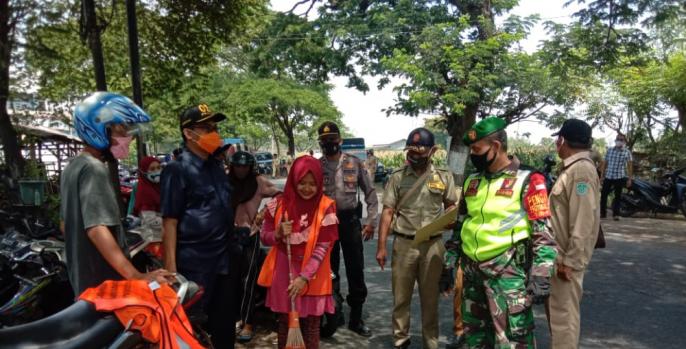 Razia masker yang digelar Pemkab Pasuruan. Salah satu pelanggar disanksi menyapu sampah di Jalan. (Foto: Dok Humas)