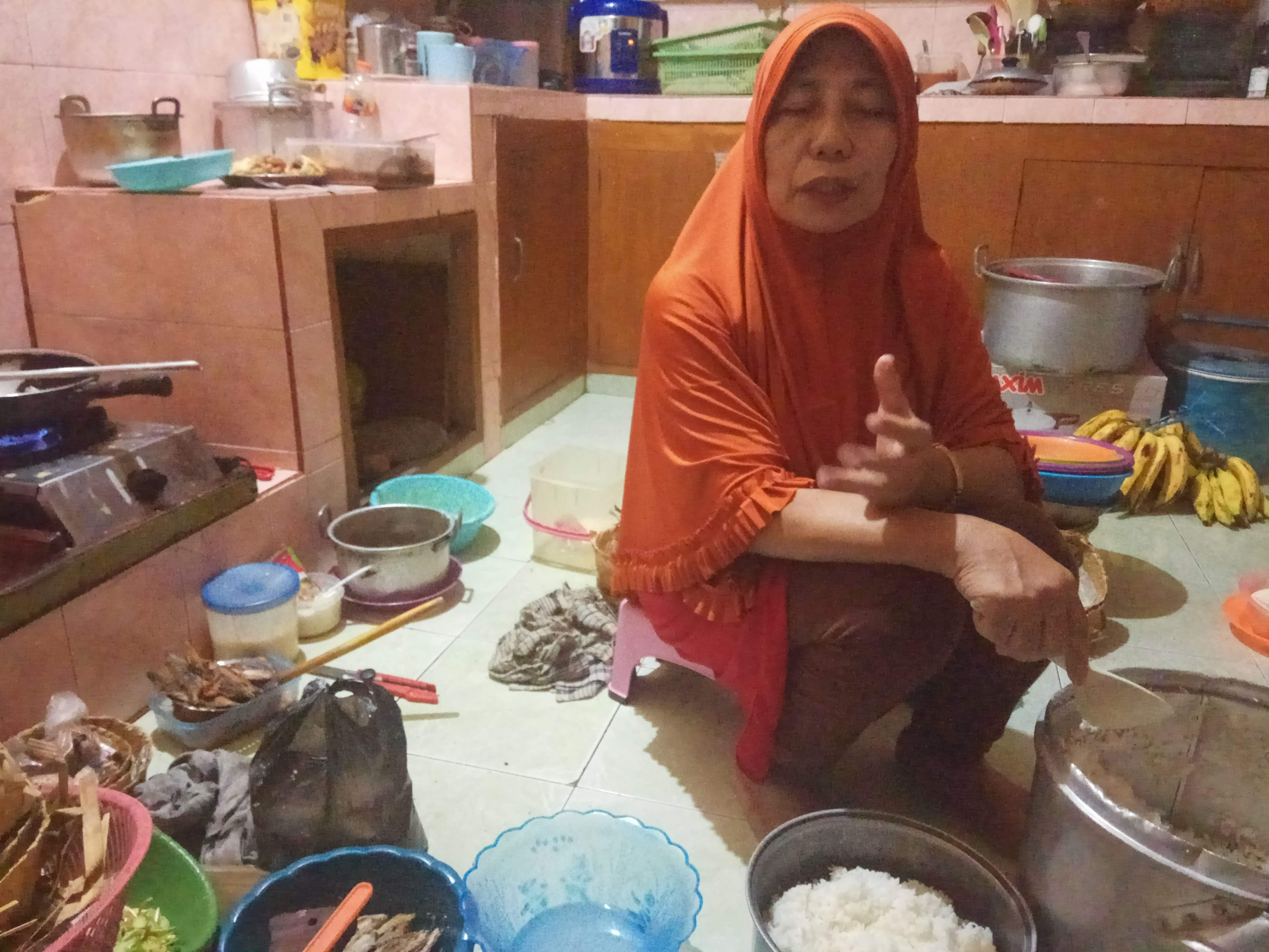 Istri Mujiarto saat memasak untuk nasi bugkus dagangannya. (Foto: Amir Tejo/Ngopibareng.id)