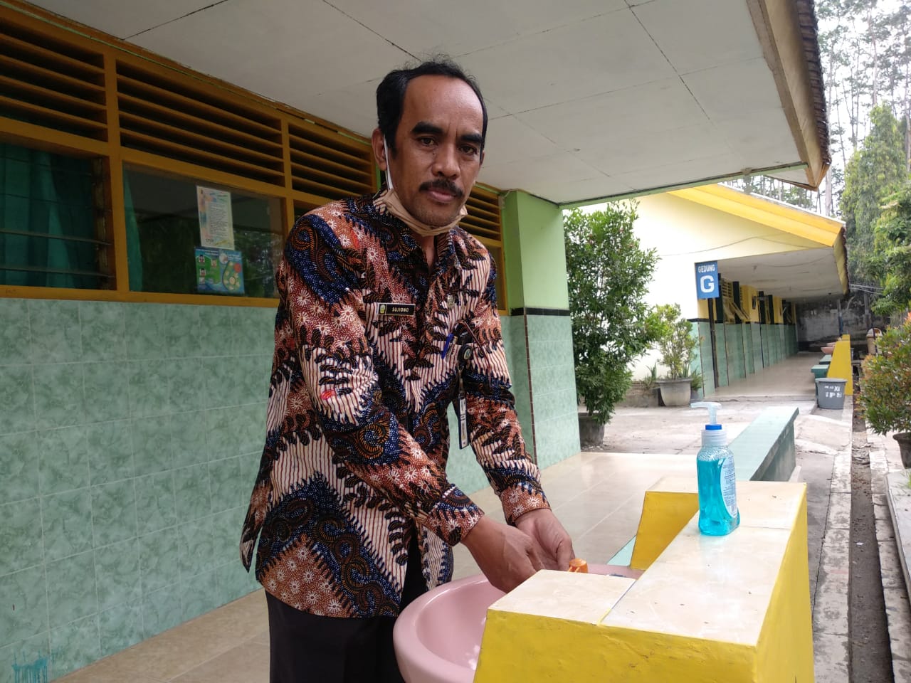 Sujiono, Kepala Sekolah SMAN Ngoro saat mencuci tangan di wastafel permanen depan ruang kelas yang terpasang sejak Juli 2020.  (Foto: M.Rizqi/Ngopibareng.id)