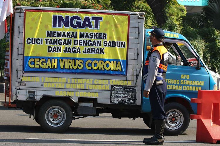 Foto dirilis Kamis 25 Juni 2020, memperlihatkan petugas gabungan melakukan penyekatan saat Pembatasan Sosial Berskala Besar (PSBB) Tahap III di Bundaran Waru, Surabaya, Jawa Timur. Sekitar 4.312 aparat gabungan diterjunkan guna mengamankan pelaksanaan PSBB di Kota Surabaya, Kabupaten Gresik, dan Kabupaten Sidoarjo, yang tiga kawasan itu lebih dikenal dengan Surabaya Raya. (Foto: Antara/Didik Suhartono) 