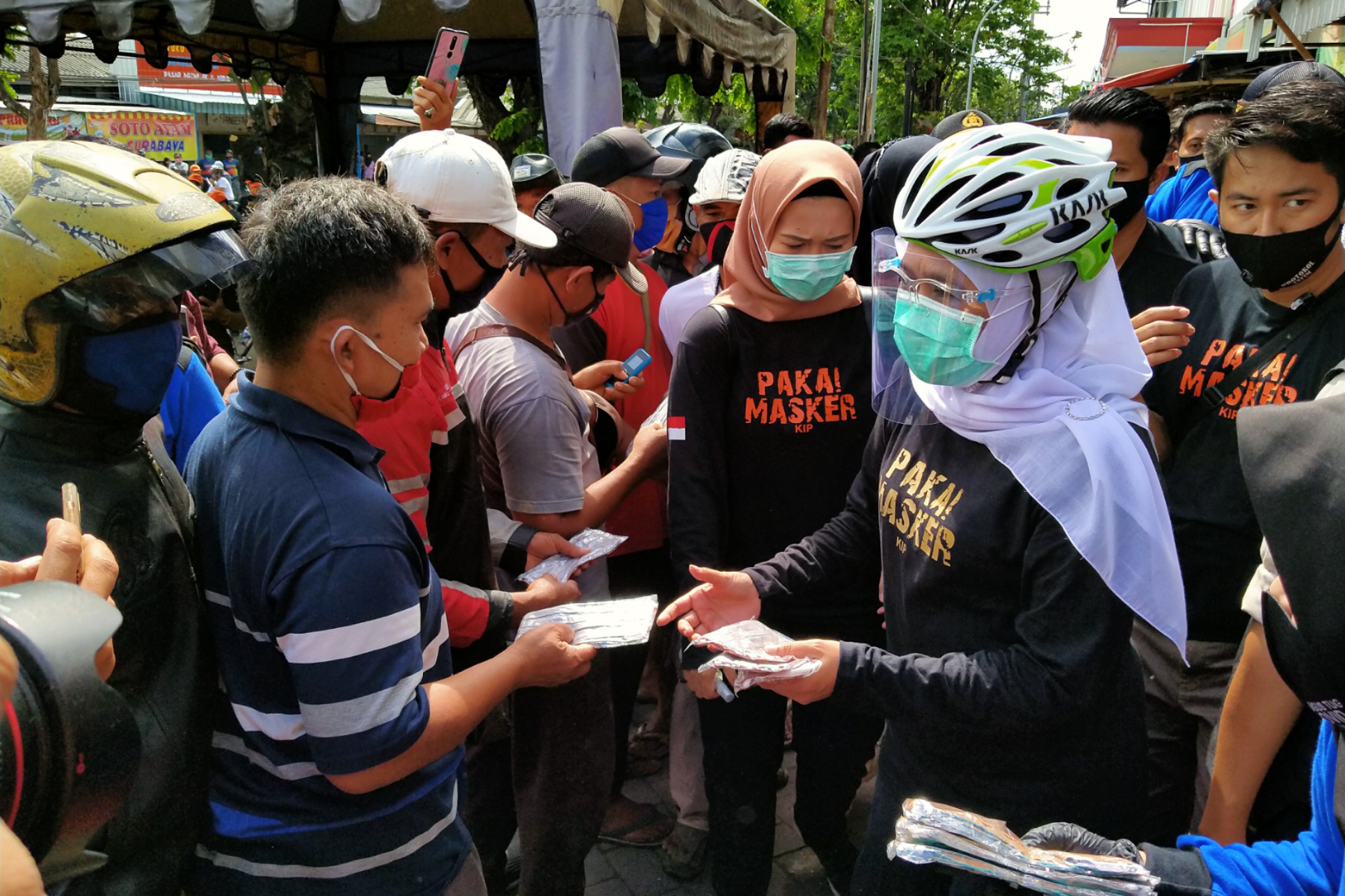 Gubernur Jatim, Khofifah Indar Parawansa membagikan masker di Pasar Ngemplak, Tulungagung, Minggu 13 September 2020. (Foto: Fariz Yarbo/Ngopibareng.id)