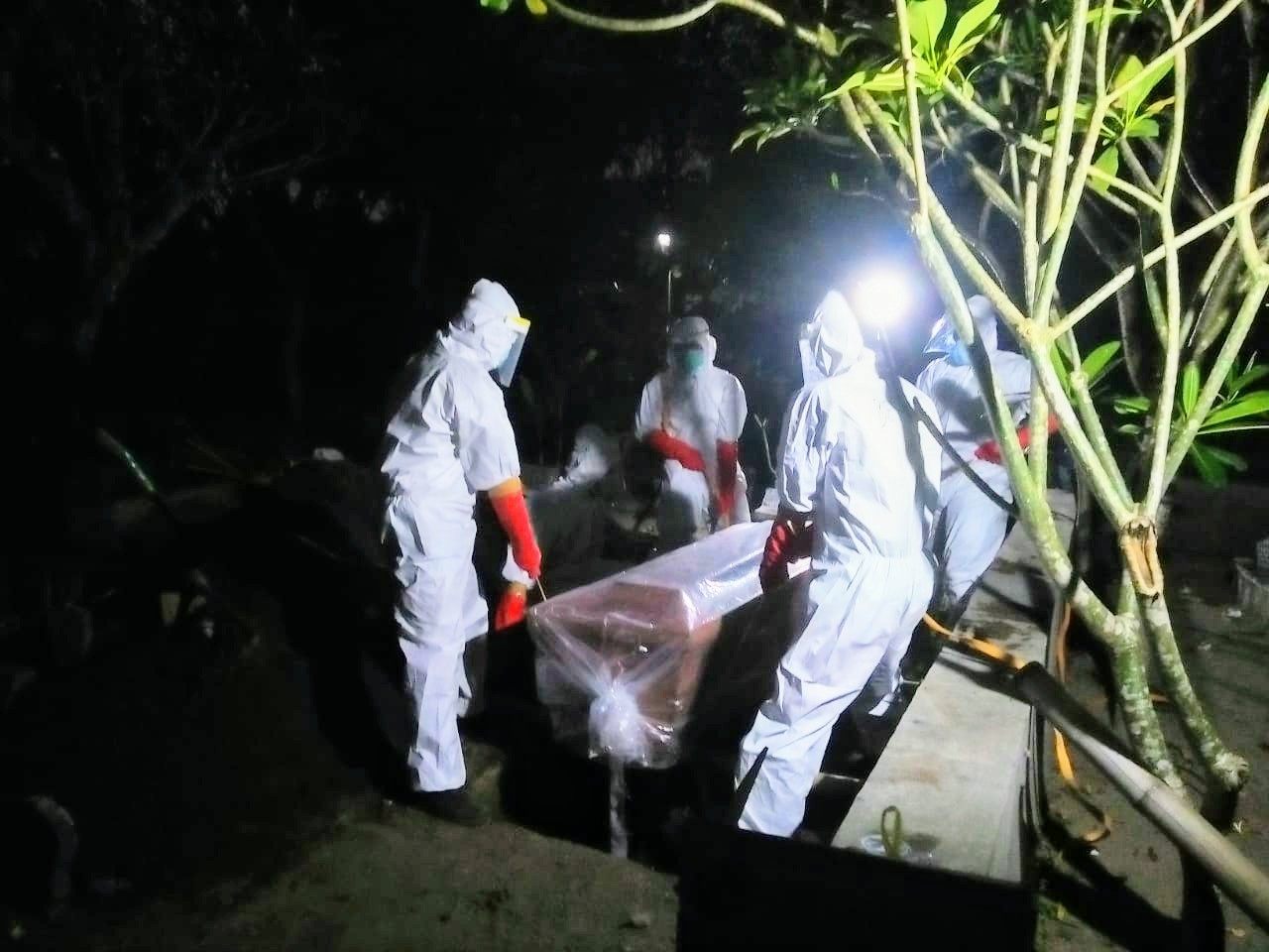 Proses pemakaman jenazah Covid saat oleh BPBD Jombang kala malam hari. (Foto: Dok. BPBD)