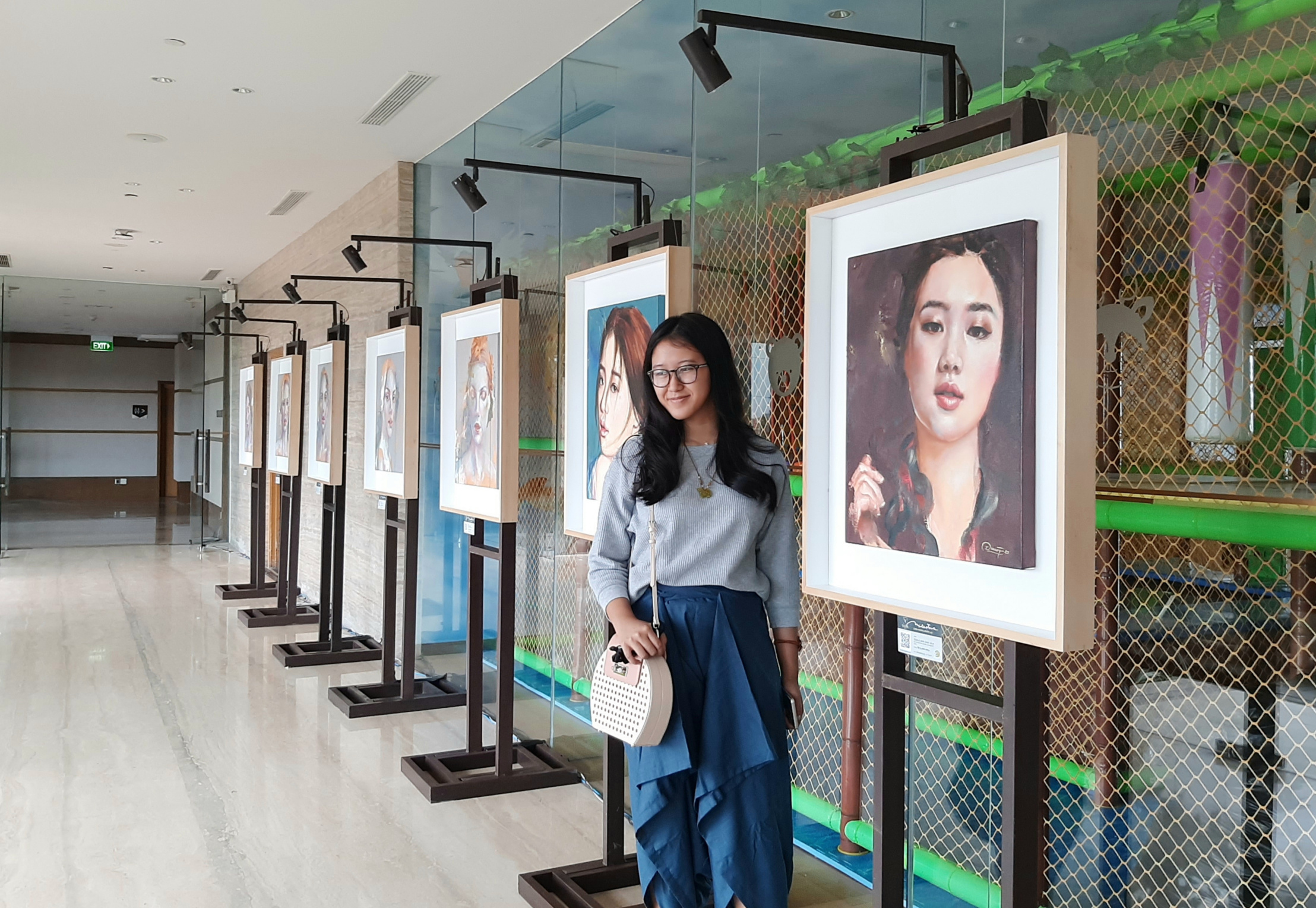 Zeta Abidin bersama dengan lukisan yang ia pamerkan dalam rangka ulang tahunnya yang ke-17 tahun. (Foto: Pita Sari/Ngopibareng.id)