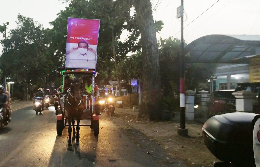 Kapolsek Kedungkandang bersama jajarannya ketika melakukan sosialisasi protokol kesehatan menggunakan dokar (Foto: Lalu Theo/ngopibareng.id)