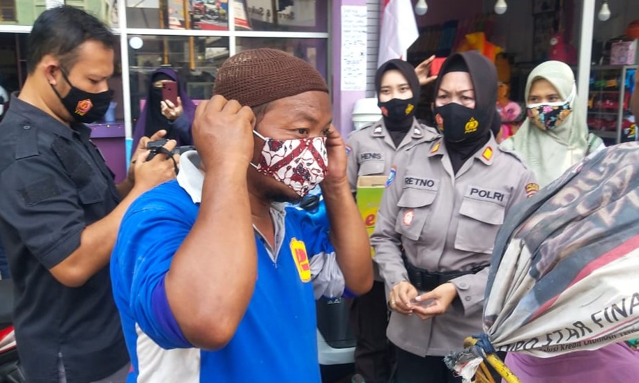 Masker scuba yang dipakai warga diganti dengan masker batik. (Foto: Ikhsan Mahmudi/Ngopibareng.id)