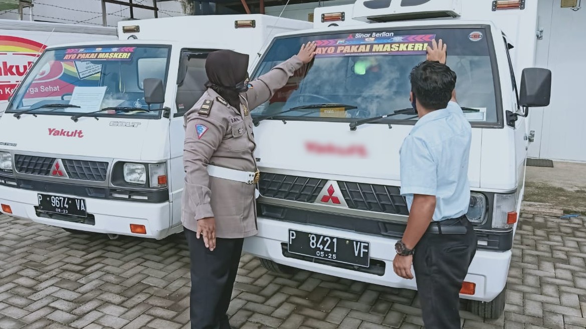 Kanit Dikyasa Satlantas Polresta Banyuwangi Iptu Datik Hariyati memasang stiker 'Ayo Pakai Masker' pada kendaraan operasional produk minuman probiotik (foto:istimewa)