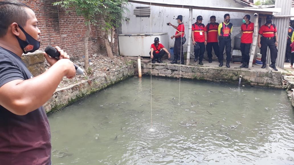 Bripka Haedy Lingga Pratama (kaus hitam) saat memberikan pelatihan budidaya lele di kolamnya. (Foto: Istimewa)