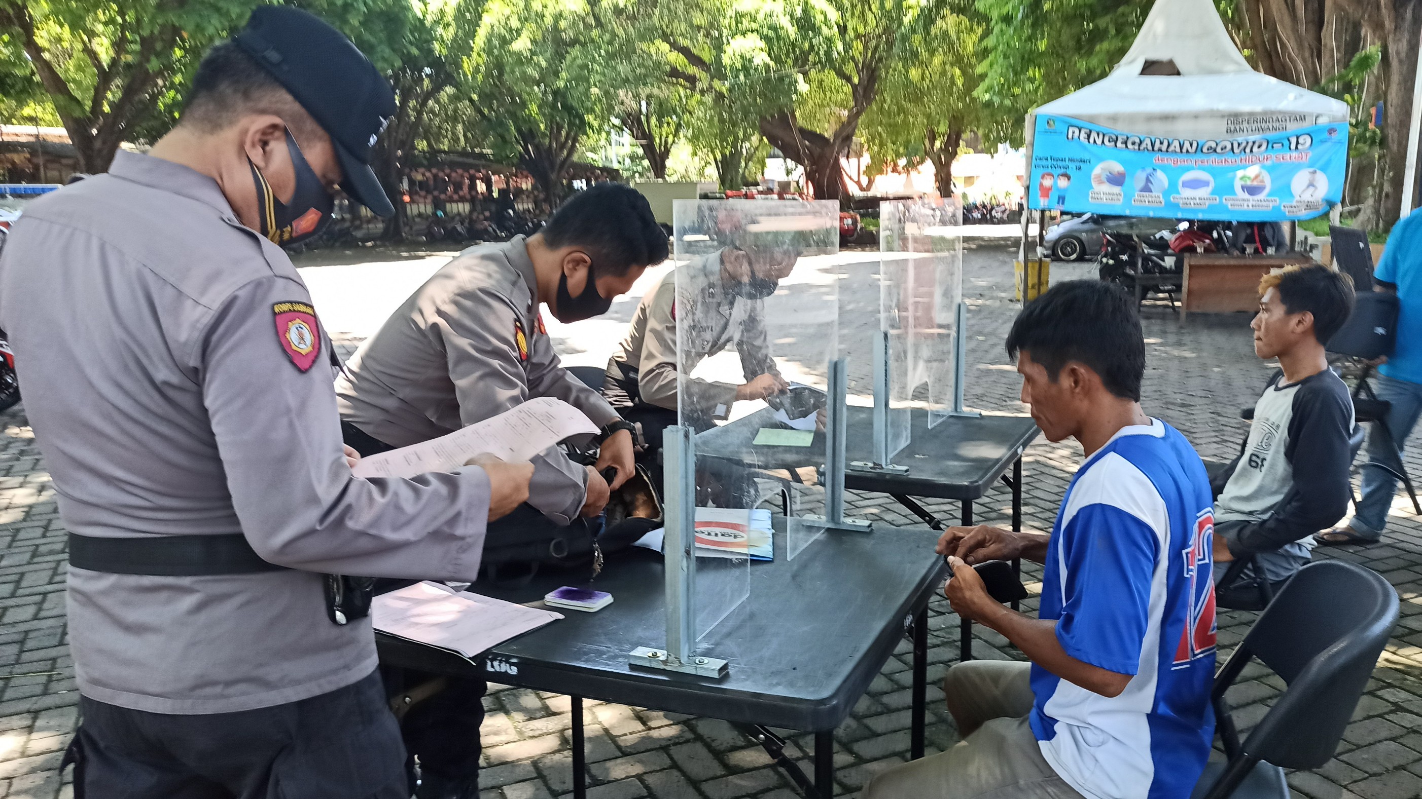 Petugas memberikan sanksi pada warga yang tidakengenakan masker (foto: Muh Hujaini/Ngopibareng.id)