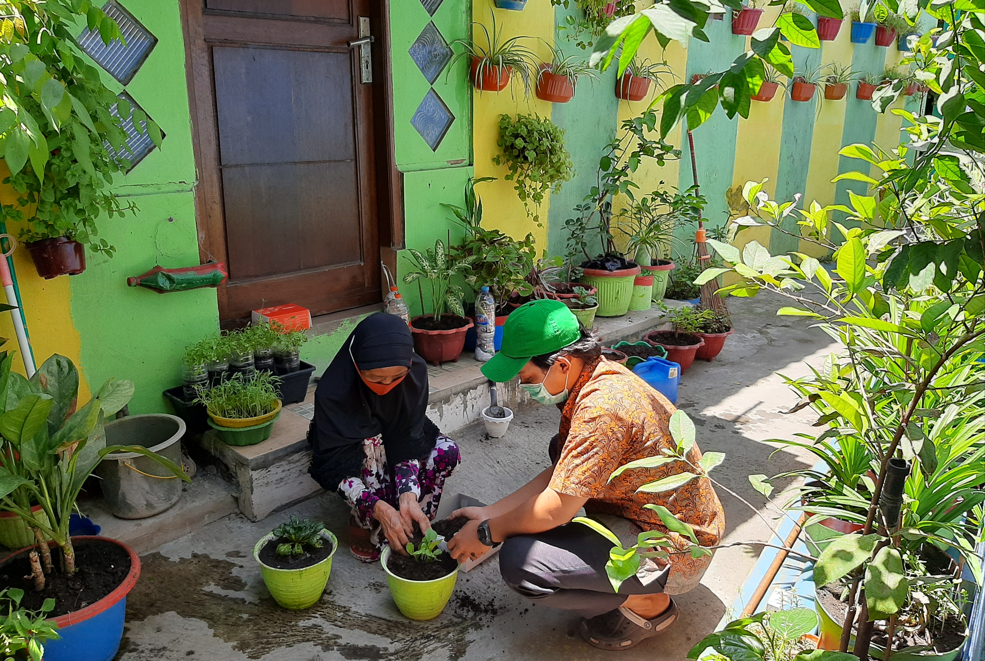 Warga RW 7 Mejoyo yang menanam bibit tanaman pemberian Ubaya. (Foto: Pita Sari/Ngopibareng.id)