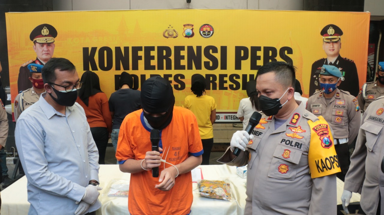 Kapolres Gresik AKBP Arief Fitrianto saat menginterogasi tersangka JRA beserta enam PSK yang berjajar di belakang. (Foto: Azharil Farich/Ngopibareng.id)