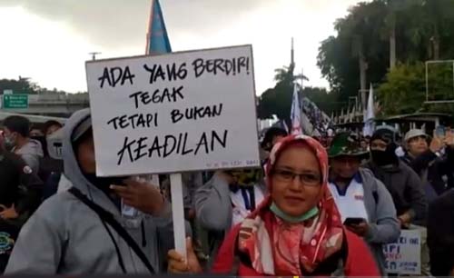 Saat demo bersama para buruh 8 Oktober lalu, ibu ini membawa poster yang membuat orang tertawa membacanya, Tapi itulah sebenarnya alasan dia ikut demo. Lunglainya keadilan. (Foto:Istimewa) 
