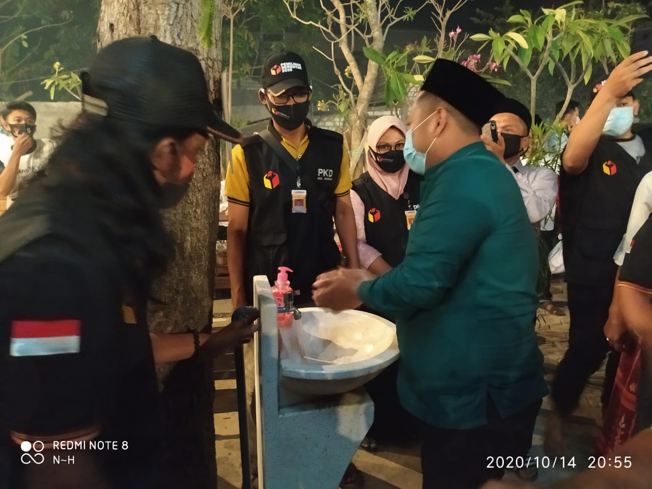 Cabup Gresik Fandi Akhmad Yani tampak mencuci tangan didampingi Ketua Panwascam Bungah Didik Hendriyono sebelum memulai kampanye. (Foto: Azharil Farich/Ngopibareng.id)