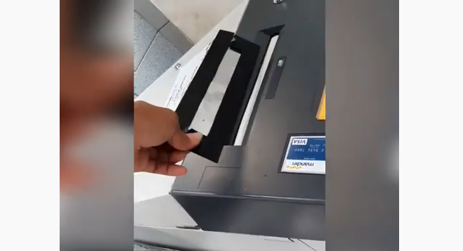 Tangkapan layar video penutup atau cover yang dilakban atau ditempeli double tape agar uang nasabah tidak keluar dari ATM. (Foto: YouTube)